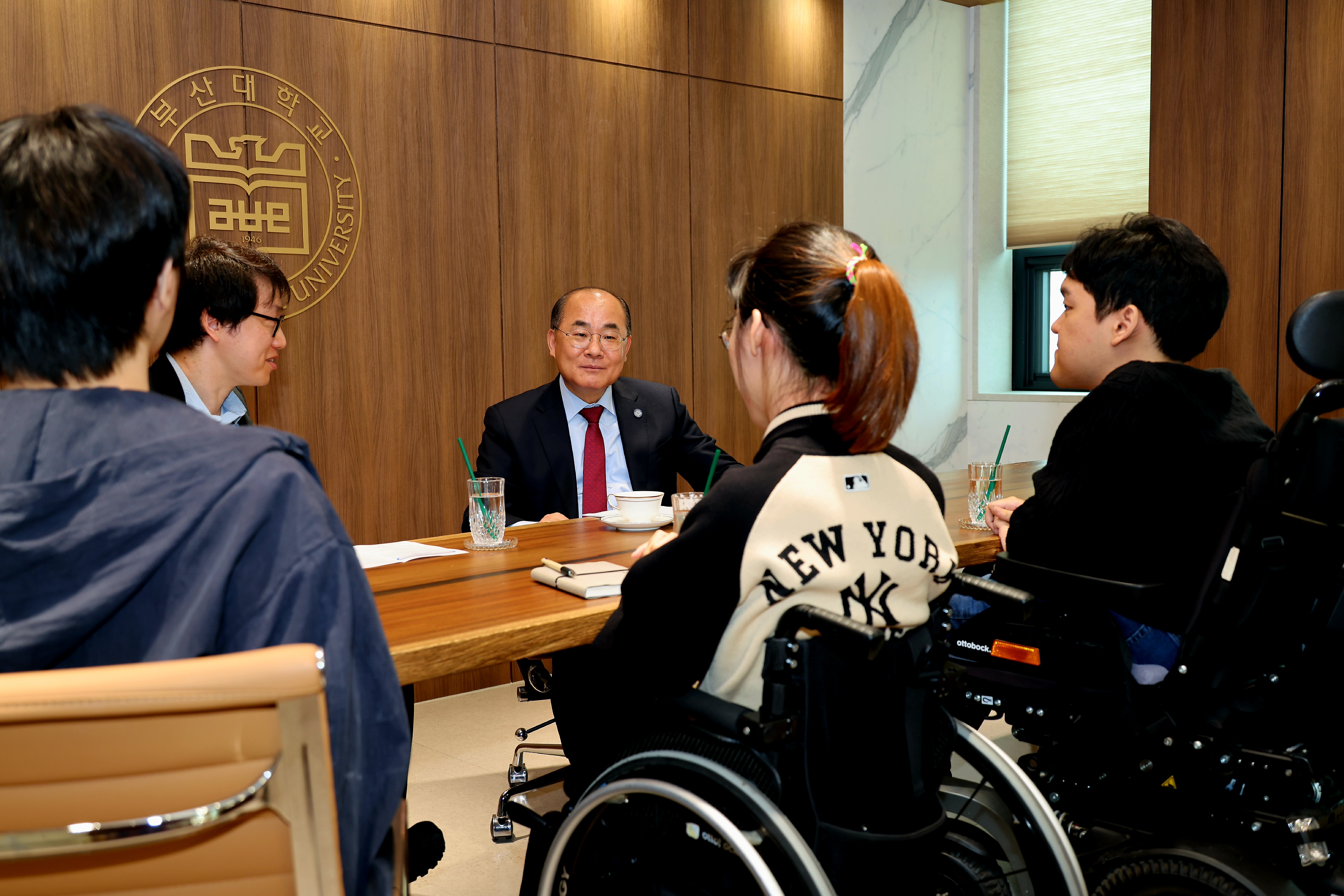 2026년 총장과의대화 1 장애학생지원센터장, 부산대학교 총장이 앉아있고 맞은 편에 장애대학원생 3명이 앉아 이야기를 나누고 있다.